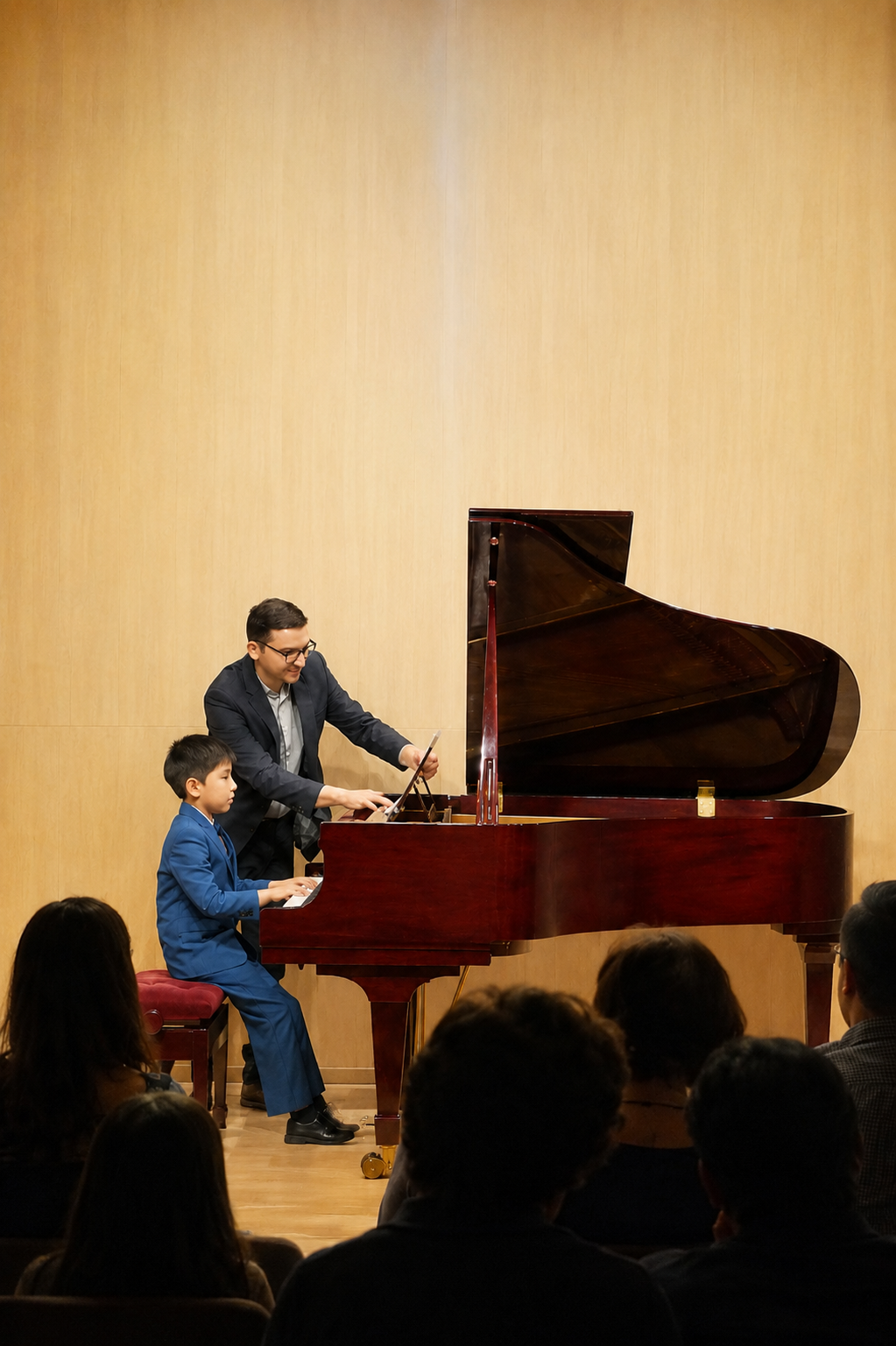 Piano teacher guiding a student during a recital at Geo Piano Studio